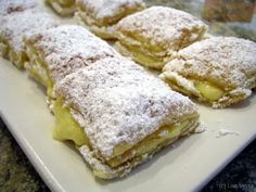 powdered sugar covered pastries on a white plate