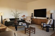 a living room filled with furniture and a flat screen tv mounted to the side of a wall