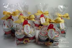 four small jars filled with candy and wrapped in cellophane