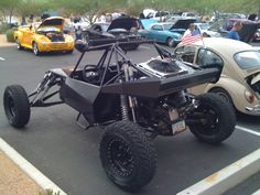 an off - road vehicle is parked in a parking lot with other cars behind it