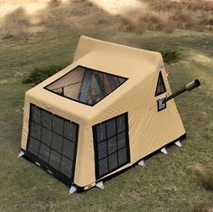 a tent that is sitting in the grass with a bat sticking out of it's side