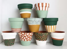 there are many cups that have different designs on them, all lined up in the same row