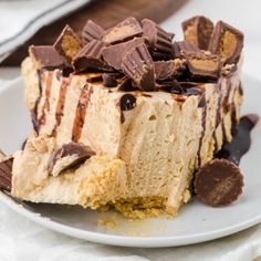 a piece of cheesecake on a white plate with chocolate and caramel toppings