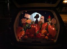 halloween decorations in the back of a car at night with pumpkins and jack - o'- lanterns