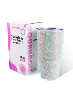 the tumbler cup is in front of a box and it has glitter on it