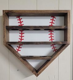 a wooden shelf with baseballs in the shape of a diamond on top of it