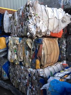 there are many bags and containers stacked on top of each other in the back of a truck