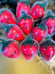 six plastic strawberries with designs on them