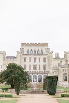 a large building with a fountain in front of it and lots of greenery on the ground