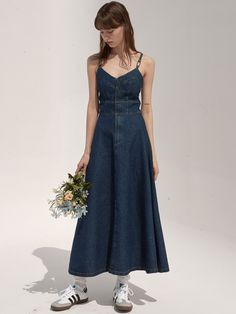 a woman in a denim dress holding a bouquet