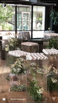 several clear vases filled with flowers and greenery