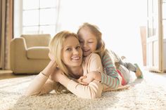 a mother and daughter laying on the floor together