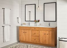 a bathroom with two mirrors and a rug on the floor in front of the sink