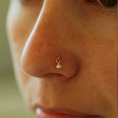 a woman's nose has a tiny pearl on it