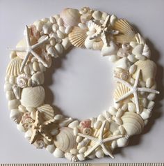 a wreath made out of seashells and starfish on a white background with measuring tape