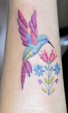 a colorful hummingbird tattoo on the wrist