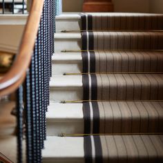 the stairs are lined with black and white checkered fabric, along with wooden handrails