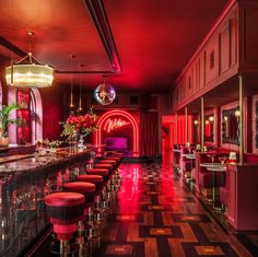 a long bar with red lights and stools