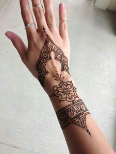 a woman's hand with henna tattoos on it