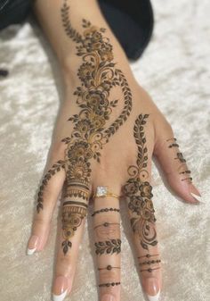 a woman's hand with henna tattoos on it