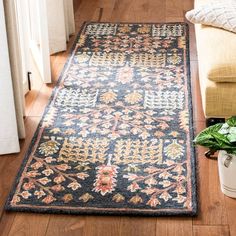 a rug on the floor with a plant in front of it and a window behind it