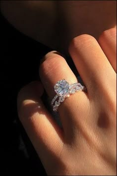 a woman's hand with a diamond ring on it