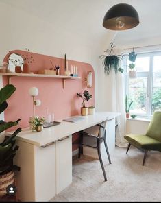 a room with a desk, chair and plants in it