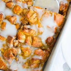 a casserole dish filled with meat and cheese covered in icing next to a white plate