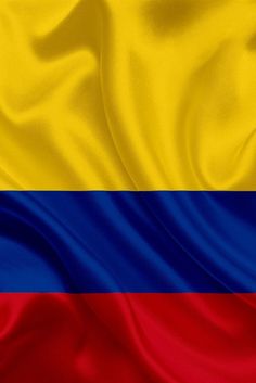 the flag of colombia is shown in red, yellow and blue fabric textured with silky folds