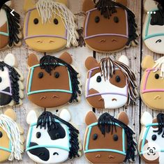 decorated cookies in the shape of horses and ponys are displayed on a wooden surface