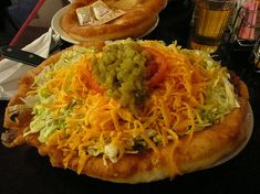 a pizza topped with cheese and guacamole sitting on top of a table