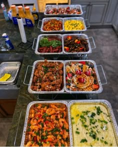 several trays of food are lined up on a counter top, ready to be served