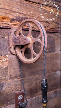 an old steering wheel hanging on the side of a wooden wall