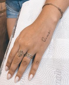 a woman's hand with a small tattoo on it