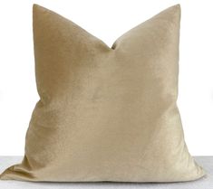 a gold pillow sitting on top of a white table