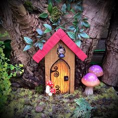 there is a small wooden house with two mushrooms next to it and a tree in the background