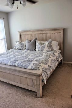 a bedroom with a bed, ceiling fan and carpeted floor in front of the window