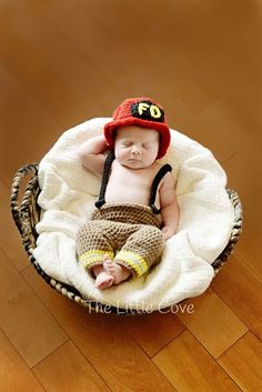 a baby wearing a hat and diaper is sitting in a basket on the floor