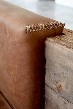 a brown leather couch sitting on top of a wooden table