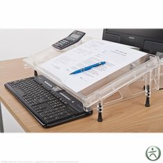 a laptop computer sitting on top of a wooden desk next to a keyboard and calculator