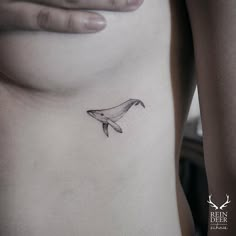 a whale tattoo on the side of a woman's stomach is shown in black and white