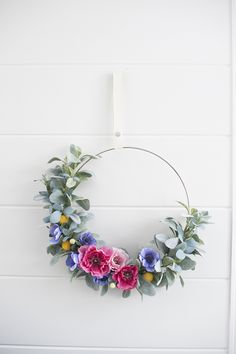 a wreath with flowers hanging on the wall