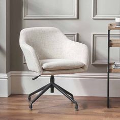 an office chair sitting on top of a hard wood floor next to a book shelf