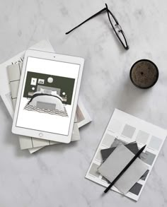 an ipad sitting on top of a table next to some papers and eyeglasses