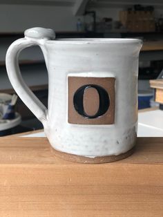 a white coffee mug sitting on top of a wooden table