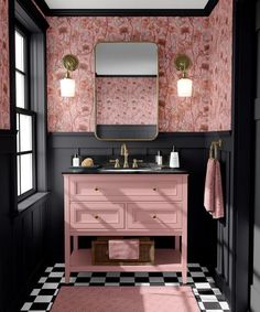 a bathroom with pink and black walls, checkered flooring and a gold framed mirror