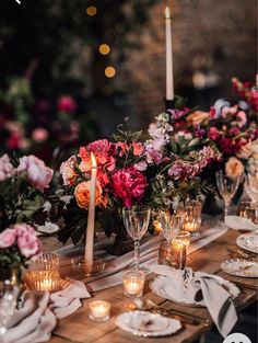 an image of a table setting with candles and flowers in the center for a wedding reception