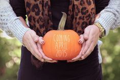 a woman holding a pumpkin with the words coming apr 2013 written on it in her hands