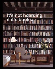 a chair and table in front of a book shelf with many books on the shelves