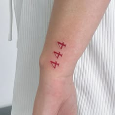 a person with a tattoo on their left wrist and the word love written in red ink